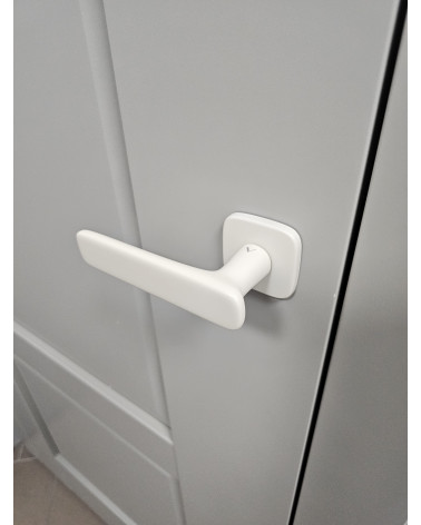 Maniglia per porta avorio opaco FLOW maniglia design vista dall'alto montata su una porta