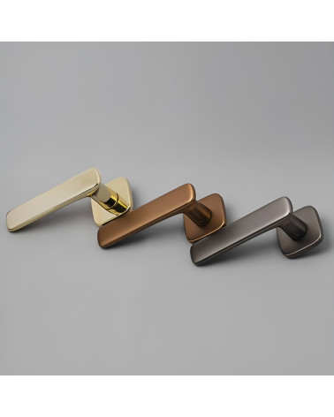 Maniglia per porta in zamak FLOW maniglia design presentata su una superficie grigia