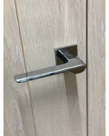Maniglia per porta cromo lucido LIGNE design vista dall'alto inclinata montata su una porta