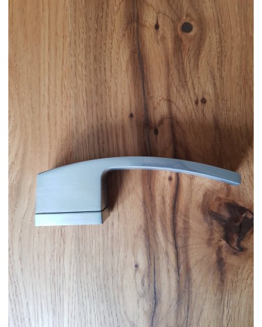 Maniglia per porta cromo satinato Arc maniglia design vista di lato posata su una placca