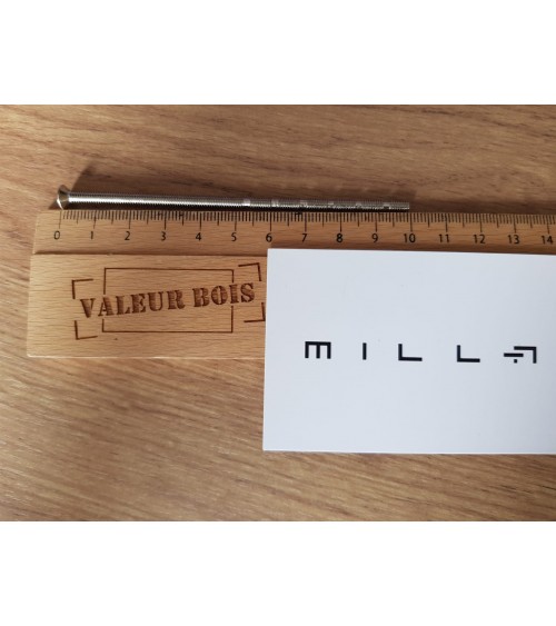 Asta filettata passante M4 da 10cm di lunghezza su un tavolo, con righello in legno e biglietto da visita bianco millapoignees