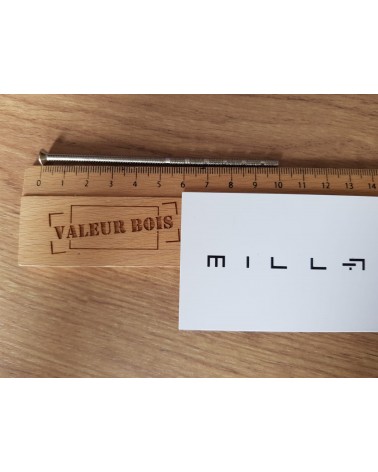 Asta filettata passante M4 da 10cm di lunghezza su un tavolo, con righello in legno e biglietto da visita bianco millapoignees