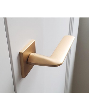 Maniglia per porta oro opaco STINGER maniglia design vista dall'alto leggermente inclinata montata su una porta