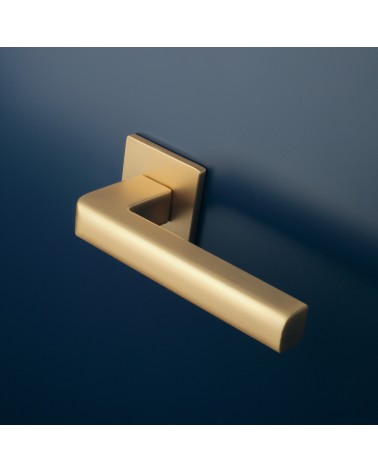 Maniglia per porta oro opaco SALICE ferramenta design montata su una porta