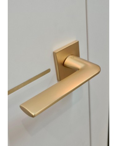 Maniglia per porta oro opaco STINGER maniglia design vista dall'alto inclinata montata su una porta