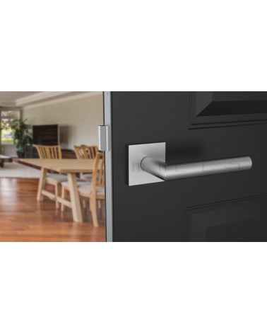 Maniglia per porta ARABIS cromo satinato ferramenta design montata su una porta socchiusa