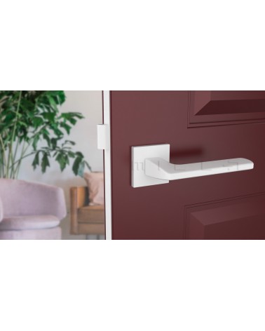Maniglia per porta bianca YUKA ferramenta design vista frontale montata su una porta