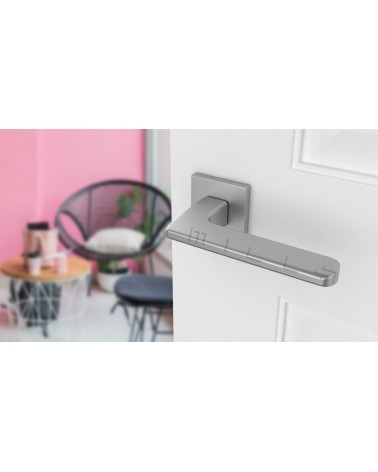 Maniglia per porta cromata satinata YUKA ferramenta design vista inclinata montata su una porta