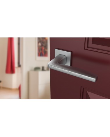Maniglia per porta ERBA design cromo satinato vista inclinata montata su una porta