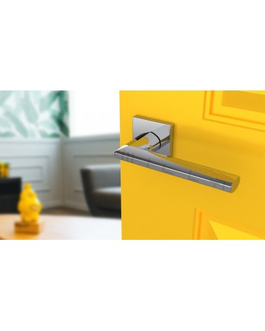Maniglia per porta cromata lucida JASMINA maniglia design vista inclinata montata su una porta