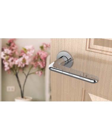 Maniglia per porta cromata lucida LIRA maniglia design vista dall'alto inclinata montata su una porta