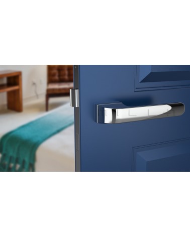 Maniglia per porta PLUMERIA in cromo lucido, vista frontale, montata su una porta