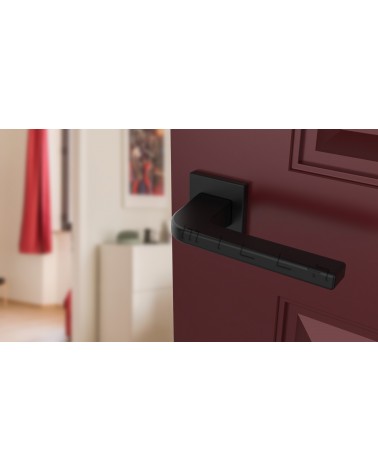 Maniglia porta nera ISMENA maniglia design montata su una porta socchiusa