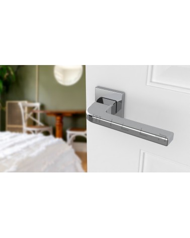 Maniglia per porta cromo lucido ISMENA maniglia design montata su una porta socchiusa