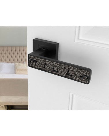 Maniglia per porta nera GLAMOUR ferramenta design vista inclinata montata su una porta