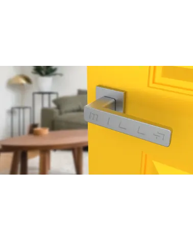 Maniglia per porta su placca quadrata ERICA ferramenta design colore 2 vista dall'alto inclinata montata su una porta