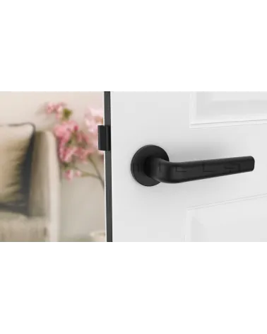 Maniglia per porta su placca rotonda INULLA maniglia design vista frontale montata su una porta