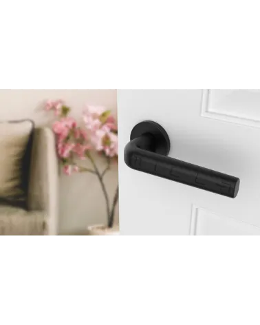 Maniglia per porta su placca rotonda INULLA maniglia design vista dall'alto inclinata montata su una porta