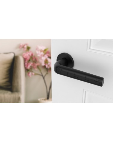 Maniglia per porta su placca rotonda INULLA maniglia design vista dall'alto inclinata montata su una porta
