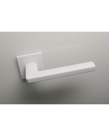 Maniglia per porta bianca PYROLA ferramenta design vista dall'alto leggermente inclinata montata su una porta