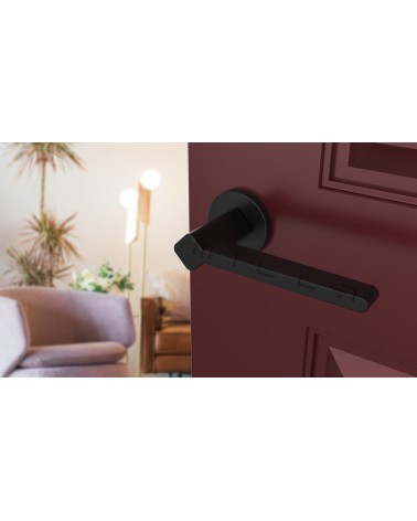 Maniglia per porta su placca rotonda NINFEA ferramenta design vista inclinata montata su una porta