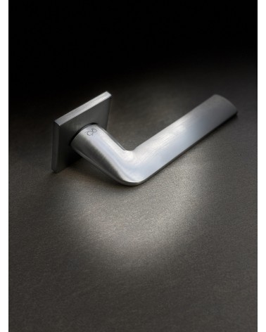 Maniglia per porta stile classico STINGER maniglia design posata su uno sfondo illuminato