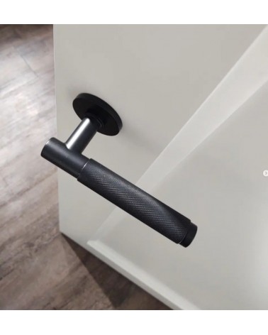 Maniglia per porta nera Time Slim design montata su una porta socchiusa vista dall'alto