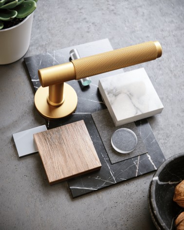 Maniglia per porta oro satinato Time Slim design posata con decorazioni