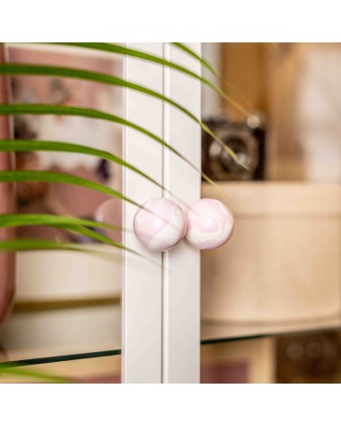 Pomello per mobile in legno di faggio Lilla design vista inclinata fissato su una porta vetrata con sfondo sfocato