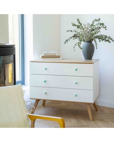 Pomello per mobile in legno di faggio verde ricco design installato su un cassettone bianco sormontato da una pianta in vaso