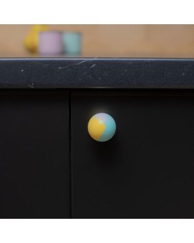 Pomello per mobile in legno di faggio giallo funky design fissato su una facciata di mobile