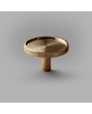 Pomolo per mobile in ottone INA maniglia design posato su uno sfondo grigio