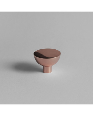 Pomello per mobile in rame LUNA M maniglia design vista frontale posato su una superficie grigia