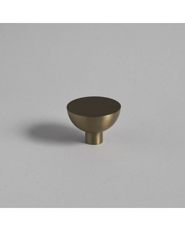 Pomello per mobile in oro opaco LUNA M maniglia design posata su una superficie piana con sfondo uniforme