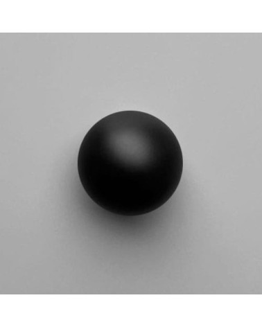 Pomello per mobile in ottone ODETE BLACK M maniglia design vista frontale su una superficie chiara