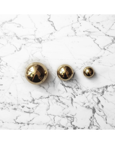 Pomolo per mobile in oro lucido ODETE design posato su uno sfondo marmorizzato