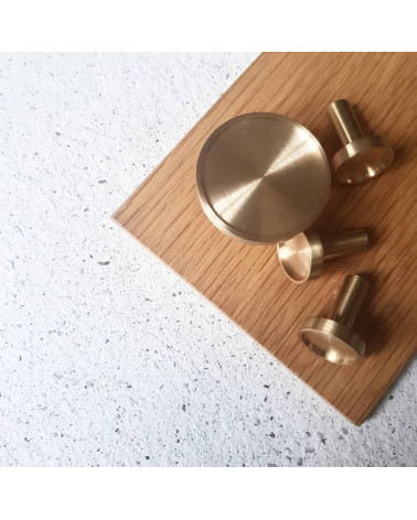 Pomolo per mobile in ottone INA design vista dall'alto posato su una superficie in legno