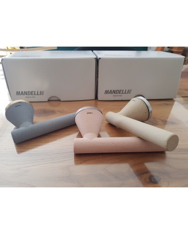 Maniglia per porta futuristica Mandelli Juno maniglia design tre colori posata su un tavolo sfondo packaging