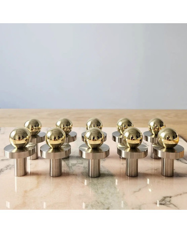 Pomello per mobile oro lucido POLA design vista frontale su piastra marmorizzata