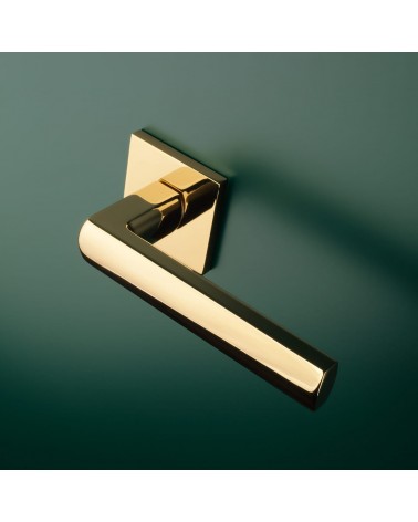Maniglia di porta oro lucido HOSTA ferramenta design montata su una porta