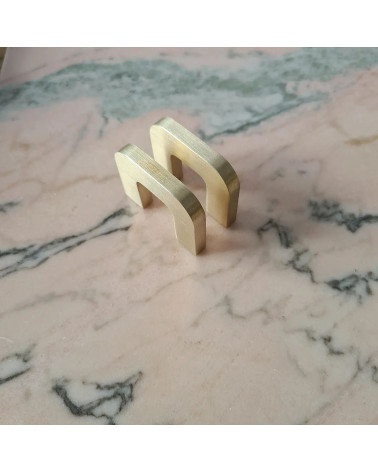 Maniglia per mobile in ottone dorato lucido ISA XS maniglia design vista in prospettiva diagonale posata piatta su una superfici