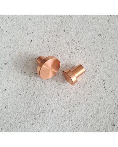 Pomello per mobile in ottone NENA maniglia design posti fianco a fianco su una superficie piana