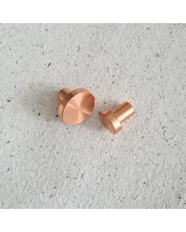 Pomello per mobile in ottone NENA maniglia design posti fianco a fianco su una superficie piana