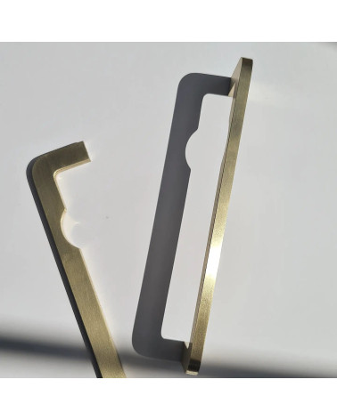 Maniglia per mobile in ottone ISA DOT maniglia design posata verticalmente su una superficie grigia