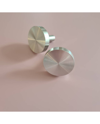 Pomello per mobile in cromo lucido NENA M maniglia di design disposta fianco a fianco su una superficie piana