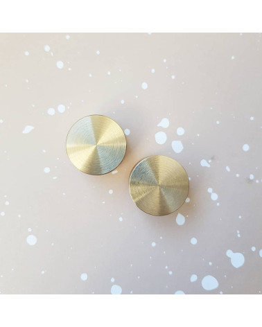 Pomello per mobile oro opaco TOVE maniglia di design vista dall'alto disposta fianco a fianco su una superficie chiara con schiz