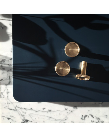 Pomello per mobile in ottone VERA maniglia design posata su un tavolo nero