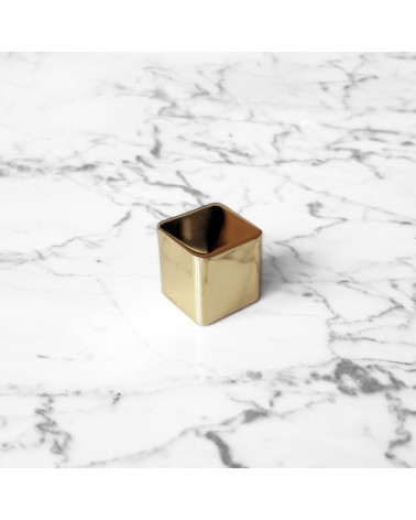 Pomello per mobile in ottone LANA S maniglia design vista dall'alto inclinata posata su una superficie marmorea