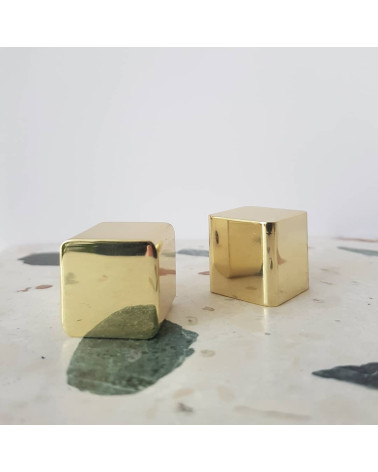 Pomello per mobile in ottone LANA S maniglia design posati su una superficie in pietra con motivo