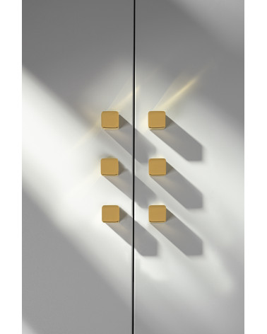 Pomello per mobile in ottone LANA S maniglia design vista frontale fissato su una porta grigia